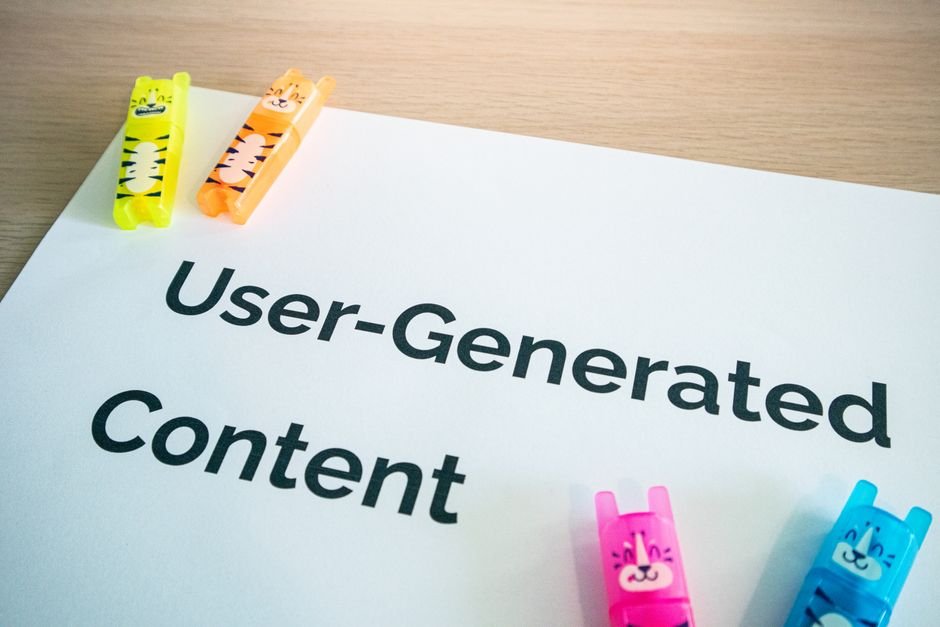 Bright highlighters on a 'User-Generated Content' note against a wooden desk.