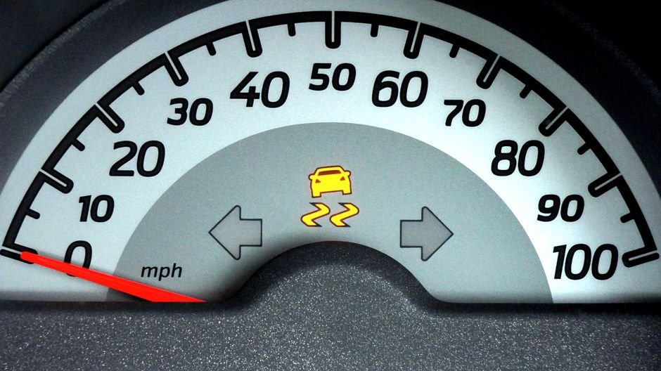 Close-up of a car speedometer displaying a warning indicator. Ideal for automotive themes.