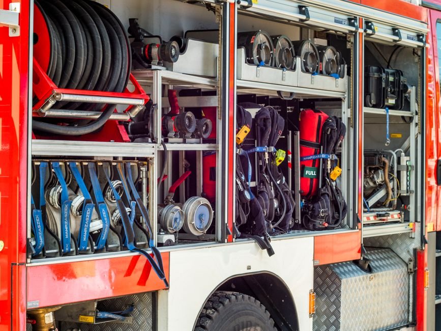 Close-up view of fire truck equipment storage showcasing hoses, tools, and gear.