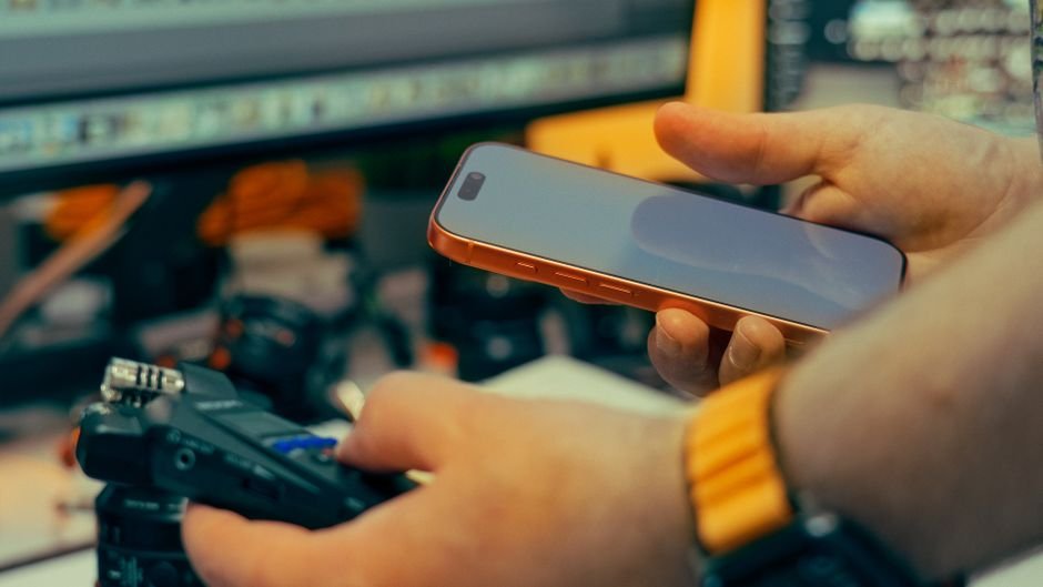 A person interacts with a smartphone and camera in an indoor studio environment. Perfect for media and production themes.