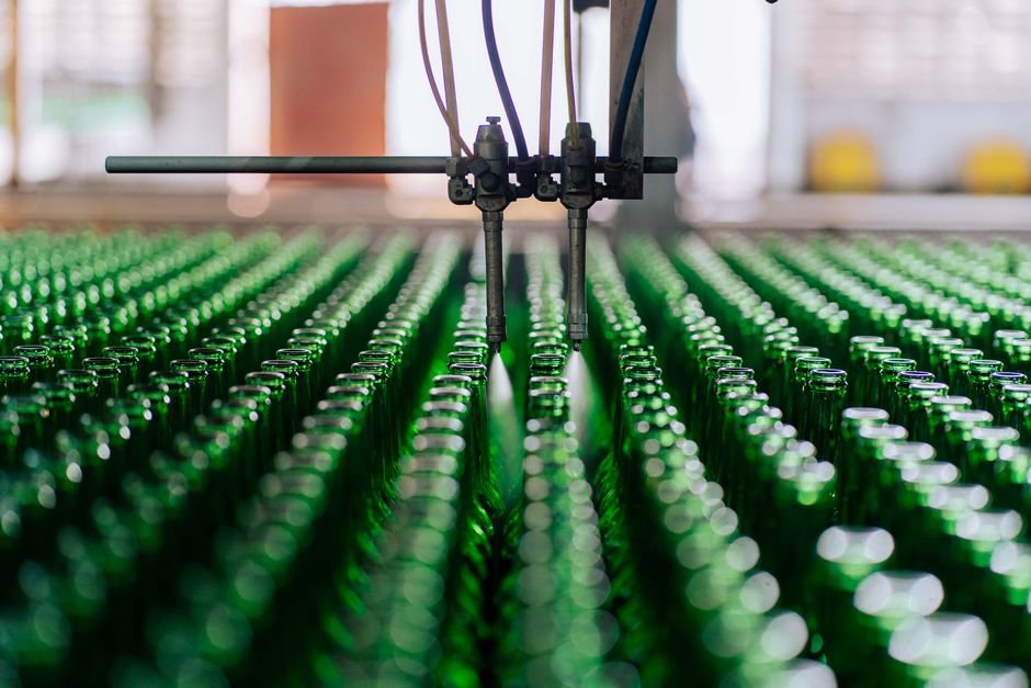 Glass bottles on an automated line in a factory, showcasing industrial glass making.